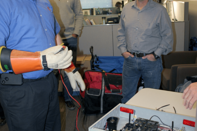Individual wearing a blue shirt engaged in NFPA 70E electrical safety training.