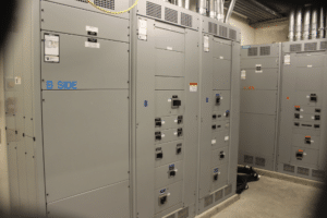 A room featuring multiple electrical panels and switches, illustrating UPS maintenance best practices for efficient operation.