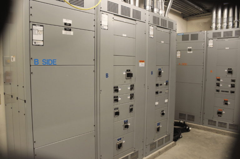A room featuring multiple electrical panels and switches, illustrating UPS maintenance best practices for efficient operation.