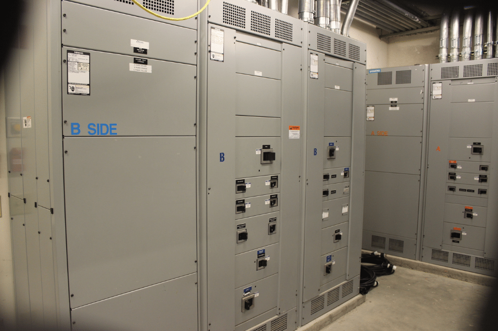 A room featuring multiple electrical panels and switches, illustrating UPS maintenance best practices for efficient operation.